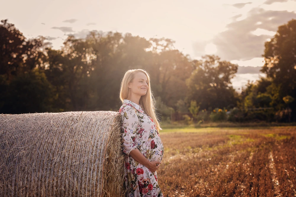 Těhotenské focení venkovní – těhotná žena u balíku sena
