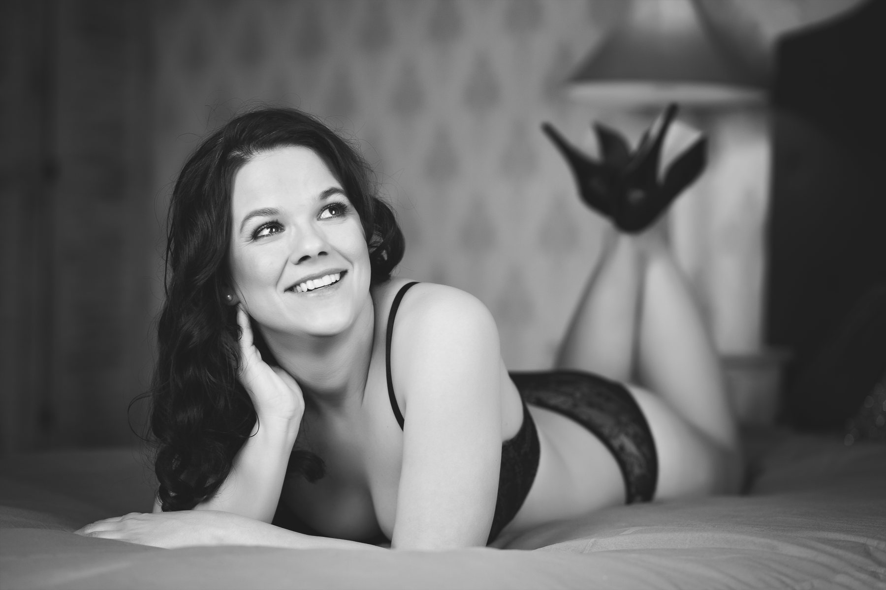 Usměvavá žena při černobílém boudoir focení