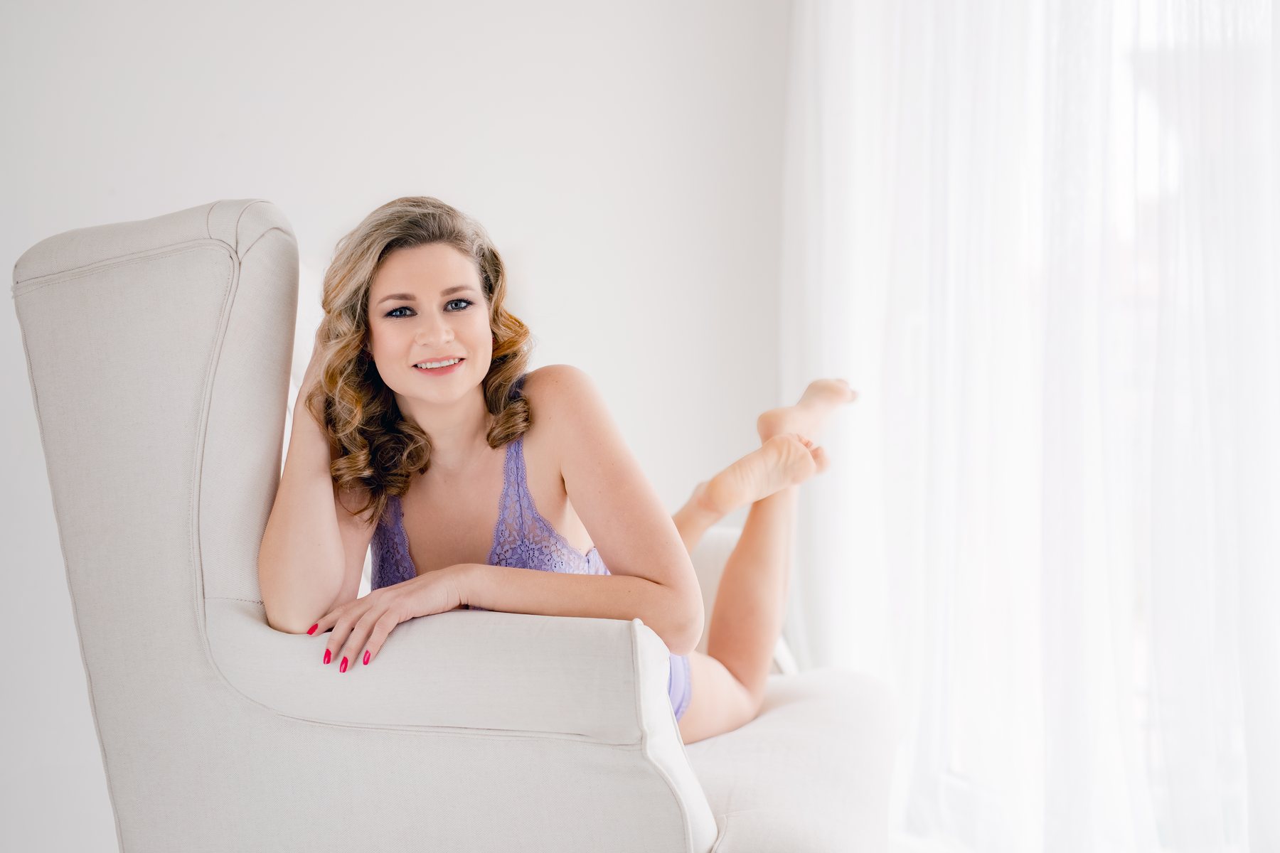 Žena při světlém boudoir focení na posteli v ateliéru