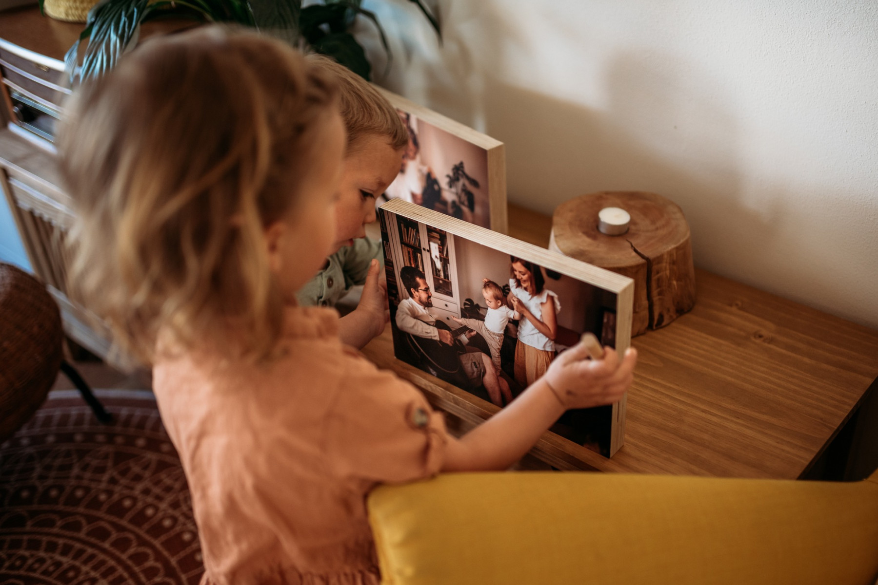 Dítě si prohlíží rodinnou fotografii na dřevěné desce