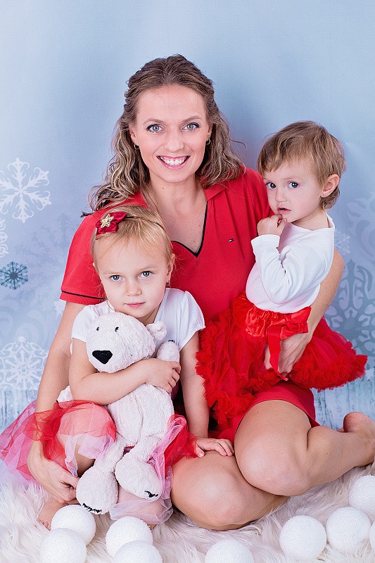Maminka se dvěma dětmi na modrém pozadí s vločkami